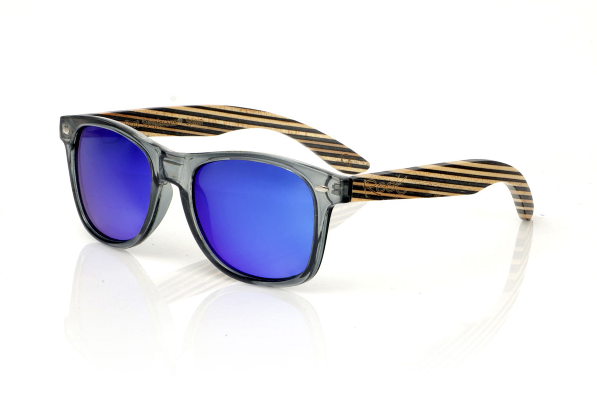 Wood eyewear of Maple SKA MIDNIGHT. SKA MIDNIGHT sunglasses, a modern twist on the classics. Its satin transparent gray  frame captures that urban vibe we all love, while the skateboard-style maple temples show off layers with natural and dark blue tones. Perfect for those who value originality and sustainability in every aspect of their life. SKA MIDNIGHT are not just glasses, they are a statement of principles. Front measurement of 150x47 mm and caliber of 52. for Wholesale & Retail | Root Sunglasses® 